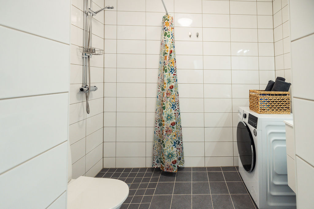 Badrum med dusch och tvättmaskin